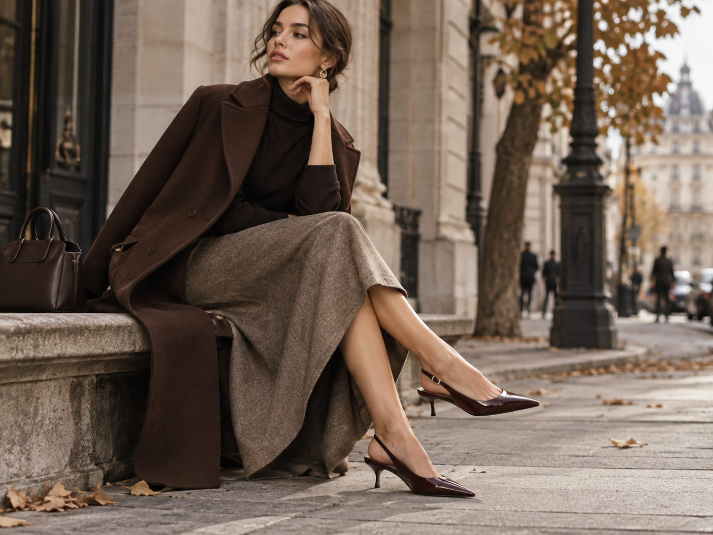 Elegantný dámsky outfit so slingback topánkami nízkym podpätkom midi sukňou a hnedým kabátom